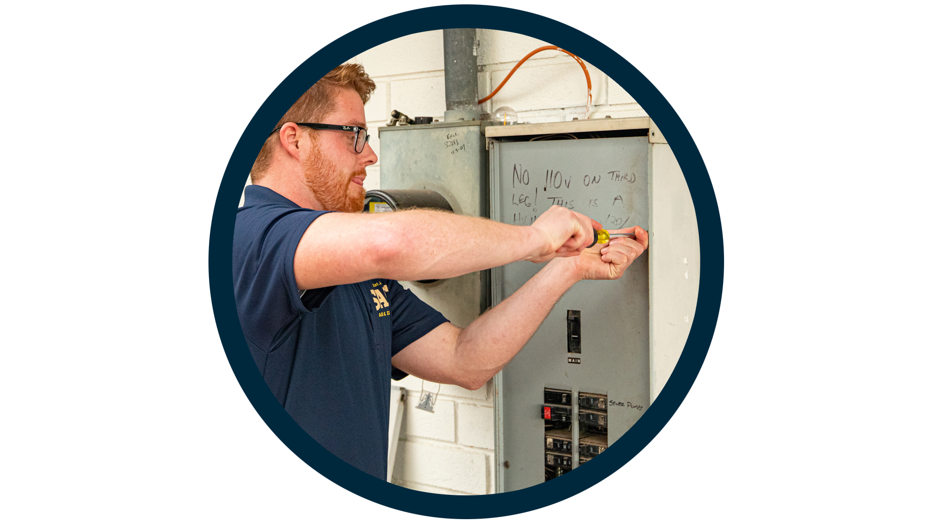 SALT electrician using a screwdriver to work on a residential electrical breaker panel, framed in a circular blue outline