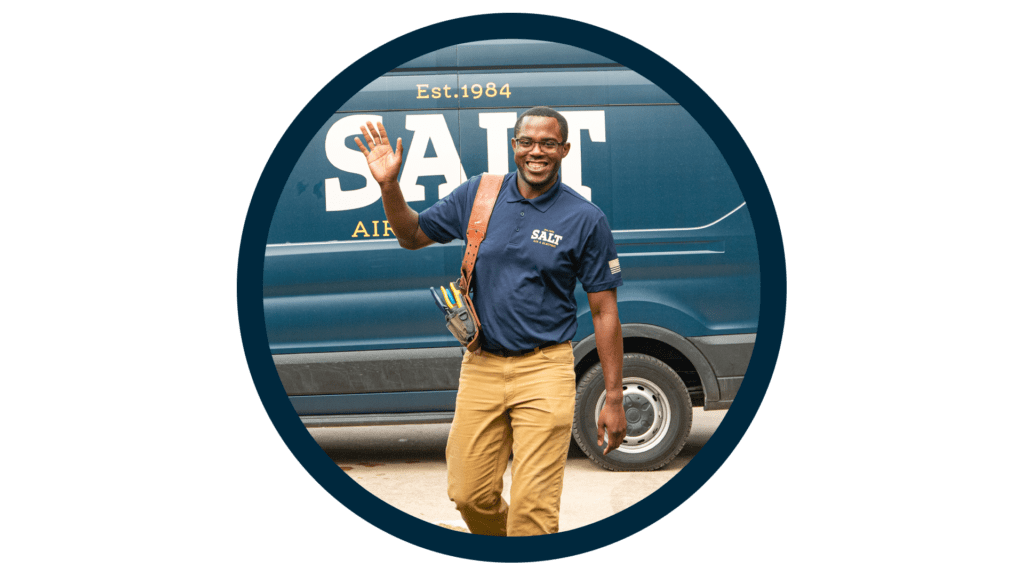 SALT technician in navy uniform carrying a tool bag, waving while walking in front of a branded company service van, framed in a circular blue outline