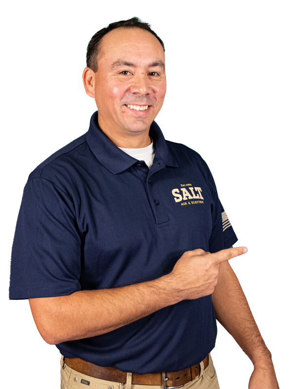 SALT technician in navy uniform smiling and pointing to the side, wearing khaki pants and standing against a white background