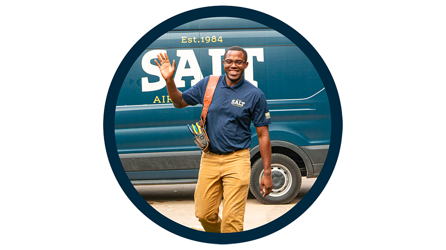 Smiling SALT technician waving while carrying a tool bag in front of a company van, framed in a circular blue outline