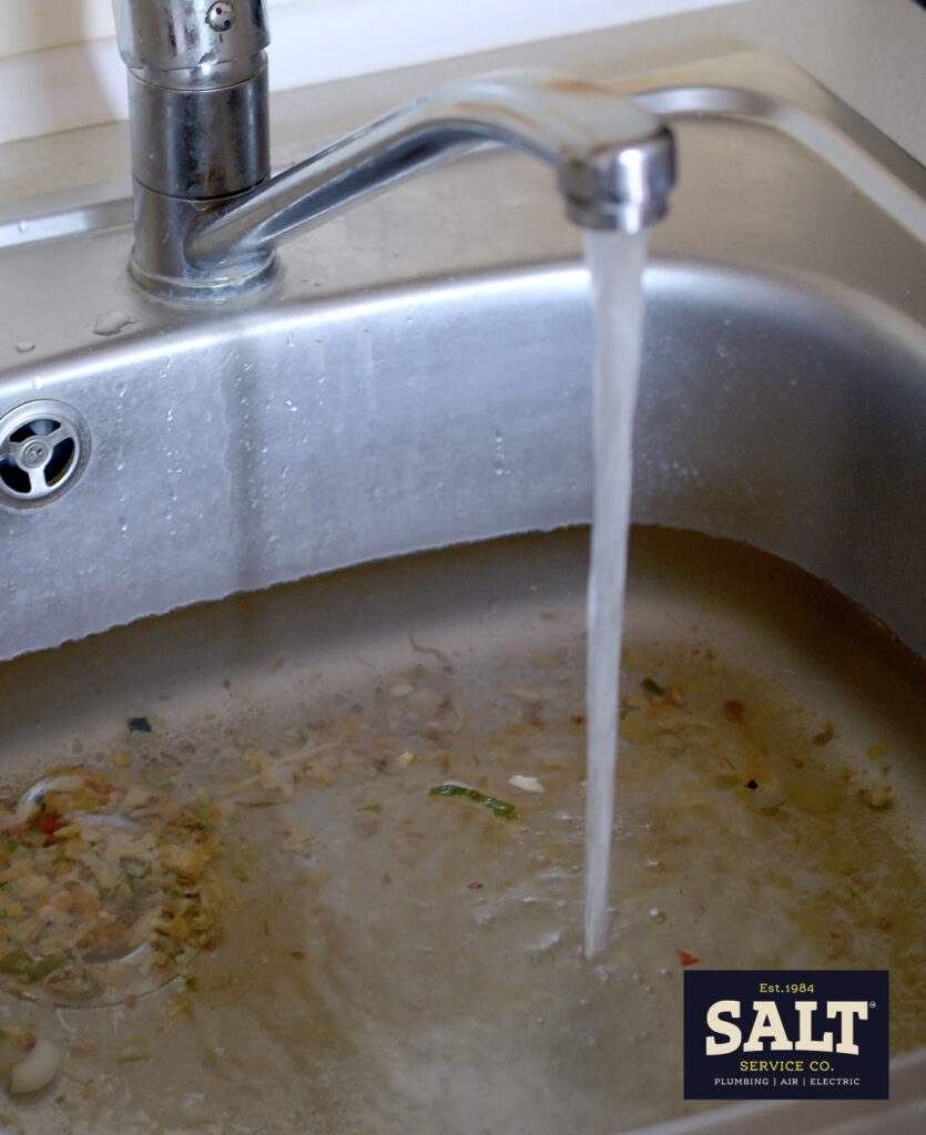 Kitchen sink with clogged drain and standing water needing professional drain service in Hutto, TX.