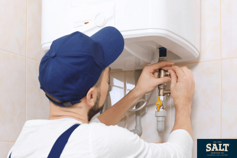Technician installing an electric tankless water heater system