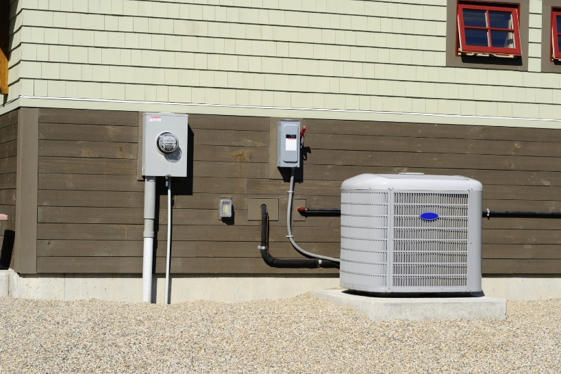 Outdoor AC condenser installed beside a home as part of a residential air conditioning replacement.